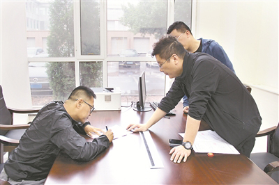 圖為李昊（左一）在談話筆錄上簽字。 尹兆書 攝